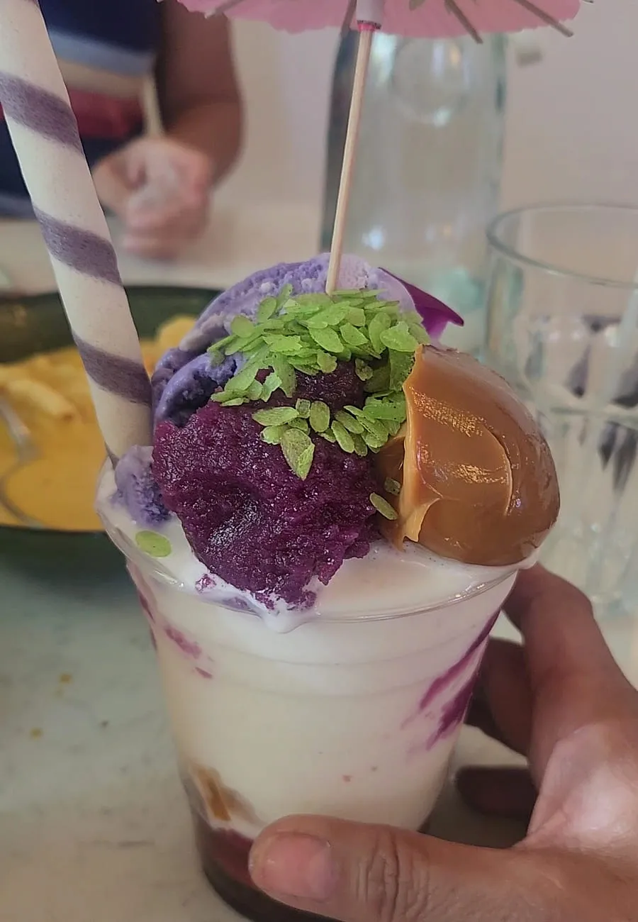 Shaved ice dessert with ube, pistachio and condensed milk served in a cup at Sno Thai Cafe Madison